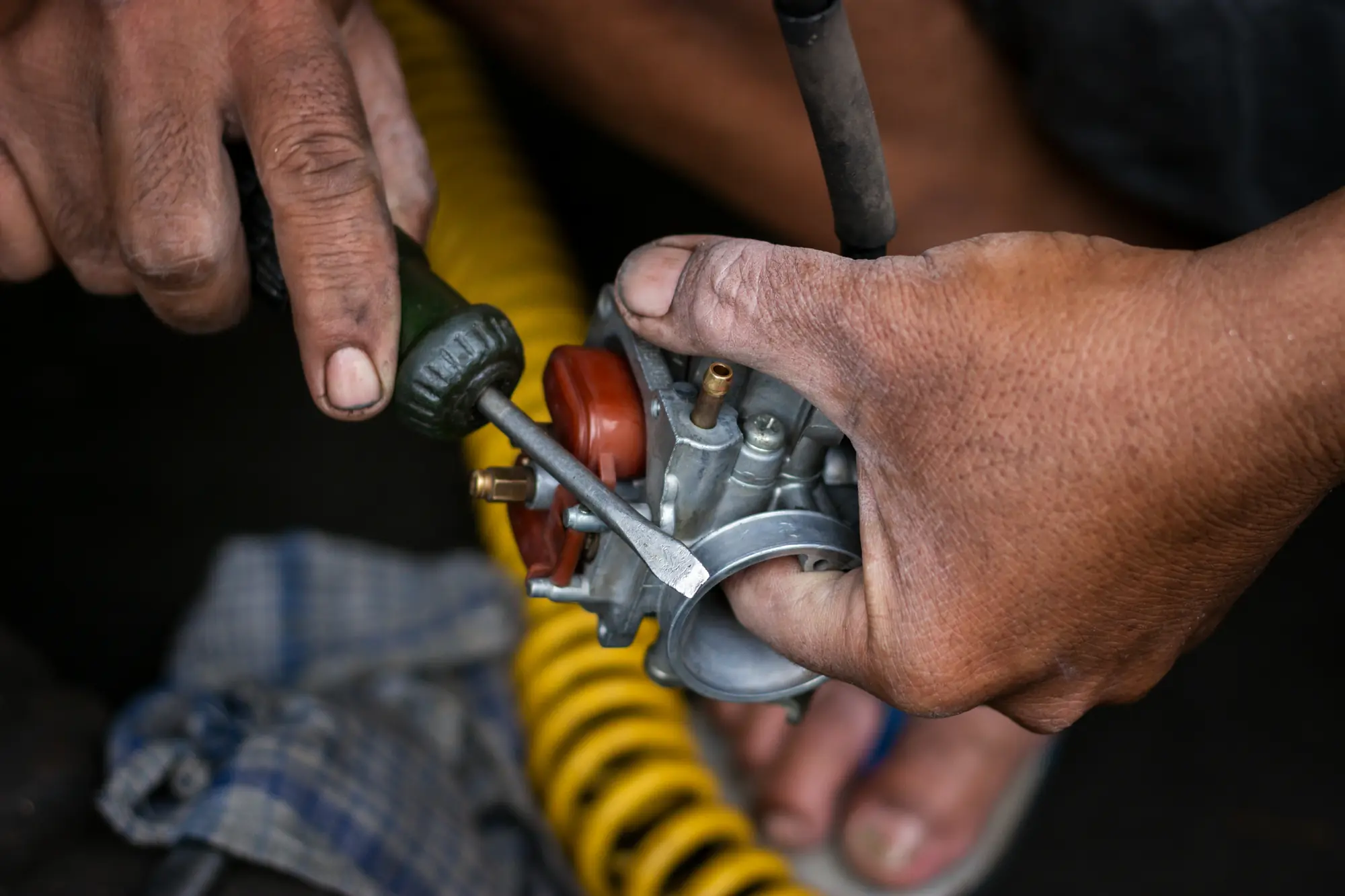 Hands repairing a carburetor